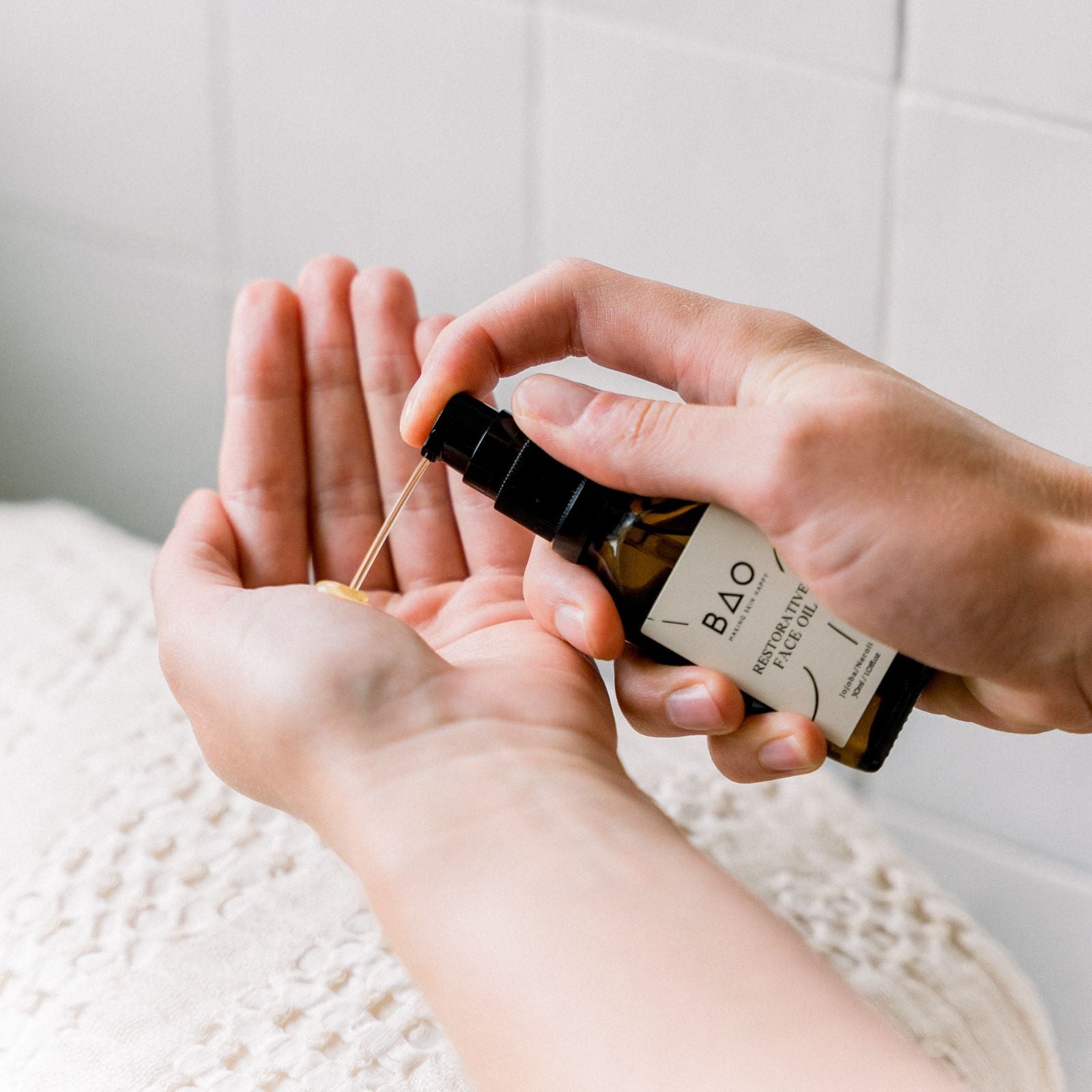 pumping organic face oil into hand